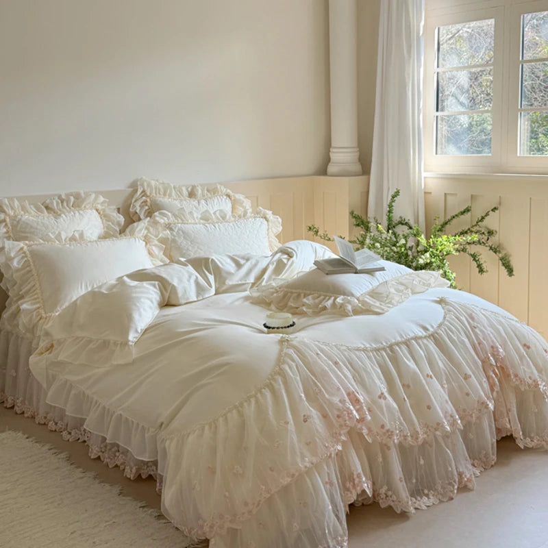 600TC Delicate white ruffled bedding set on a bed in a softly lit room with a window and plant.