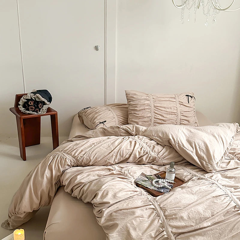 Bed with beige bedding in a minimalistic bedroom.