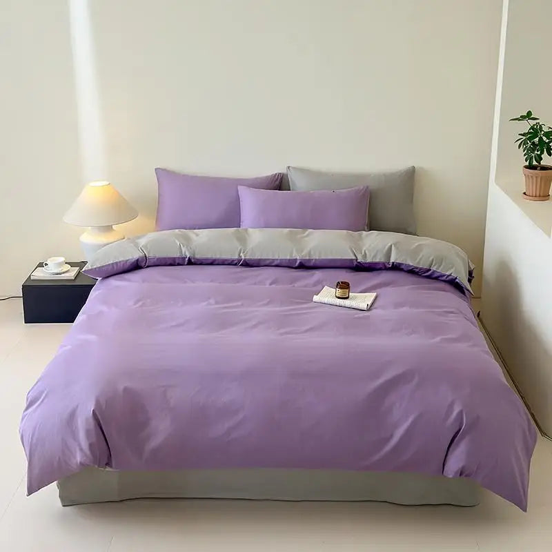 Bed with purple bedding in a minimalistic room.