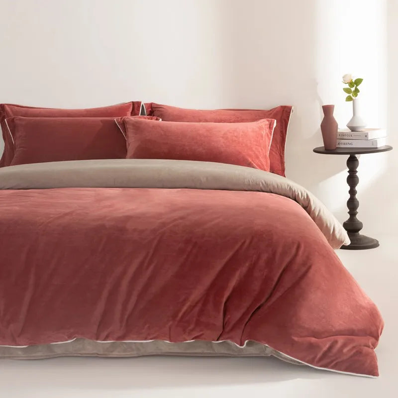 Bed with red rust bedding and pillows in a bedroom setting.