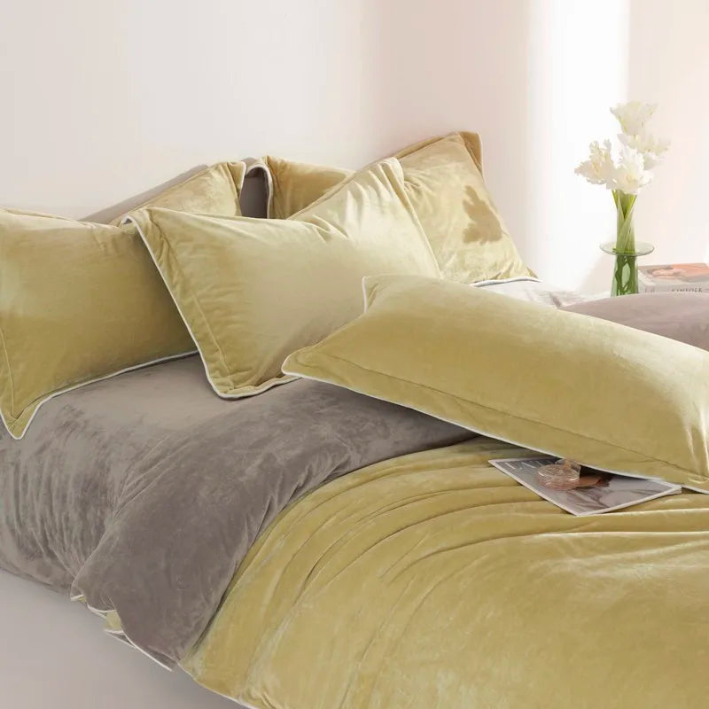 Bed with yellow and gray bedding and pillows in a bright room.