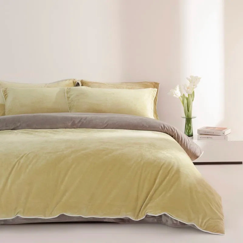Bed with yellow bedding and gray comforter in a minimalistic room.