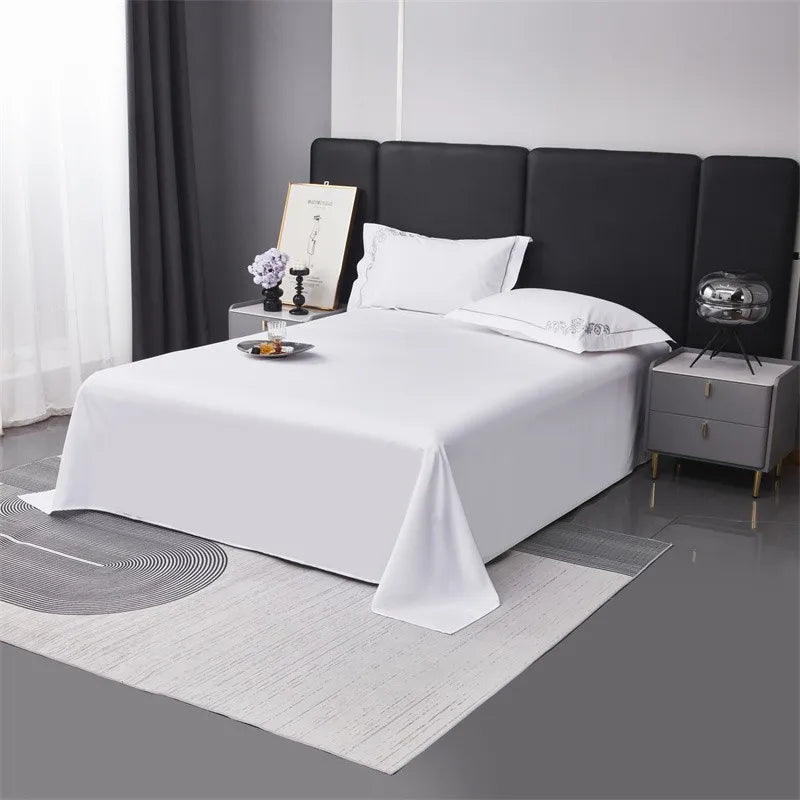 Bedroom with a bed covered in white bedding and pillows, nightstands with decorative items.
