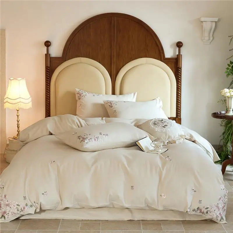 Bedroom with a wooden headboard and white bedding with floral patterns.