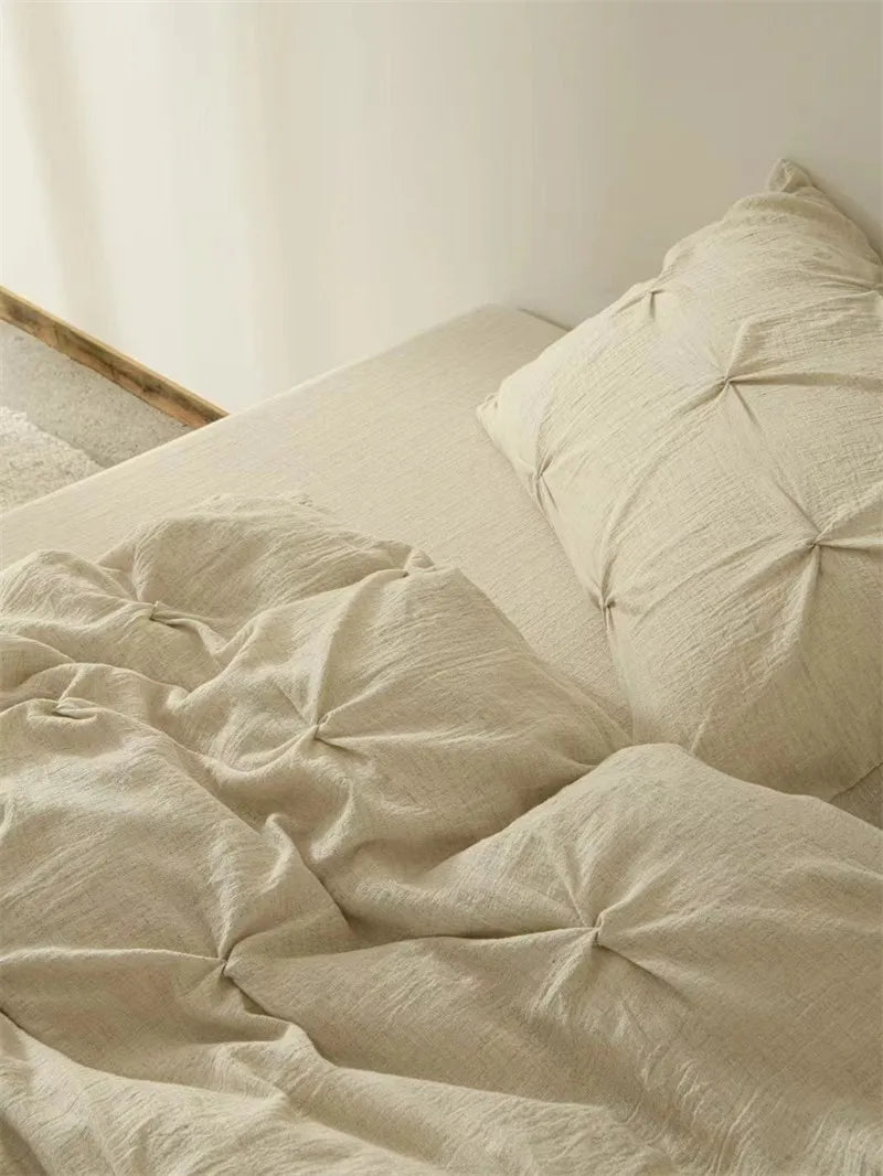 Beige bedding set on a bed with a neutral background