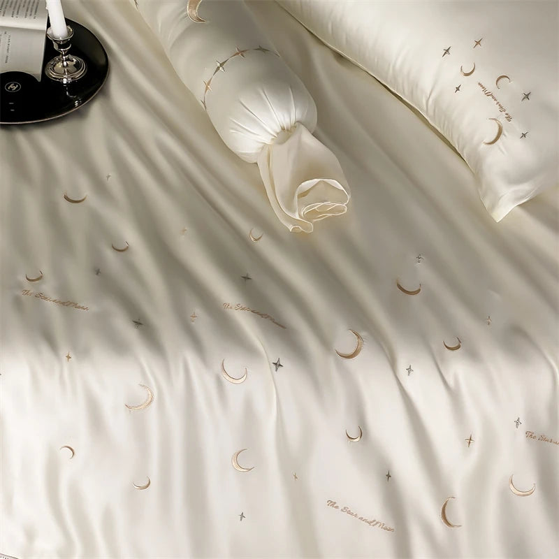 Beige bedding set with moon and star patterns on a bed.