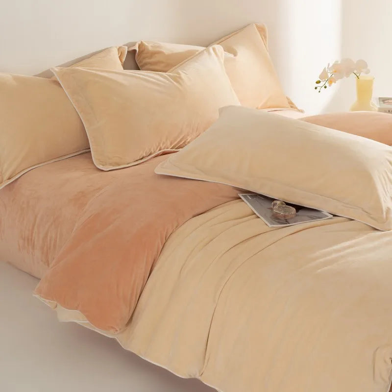 Beige bedding set with pillows and a blanket on a bed.