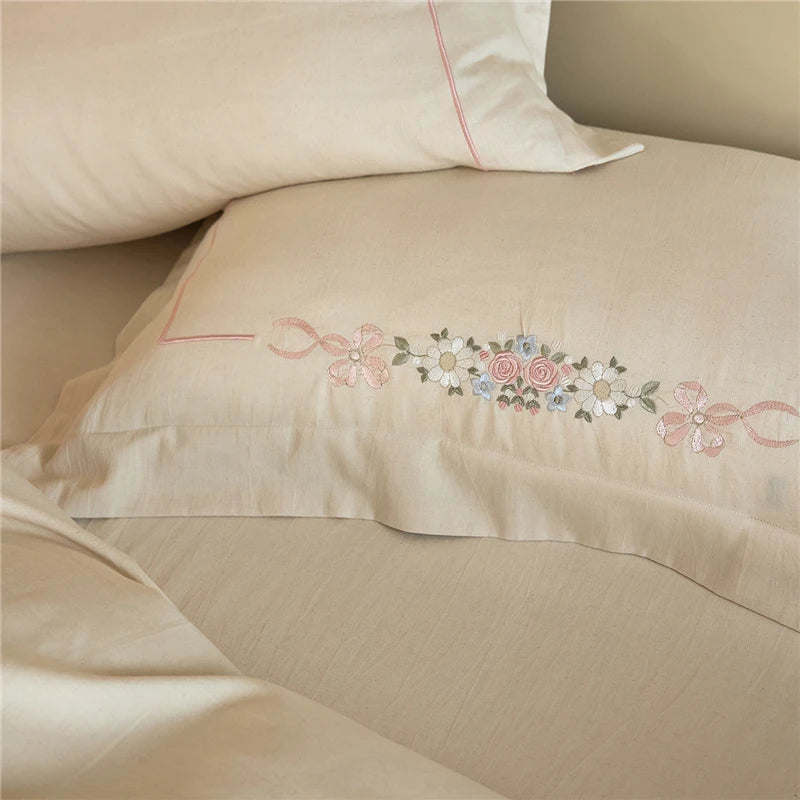 Beige pillow with floral embroidery on a beige background