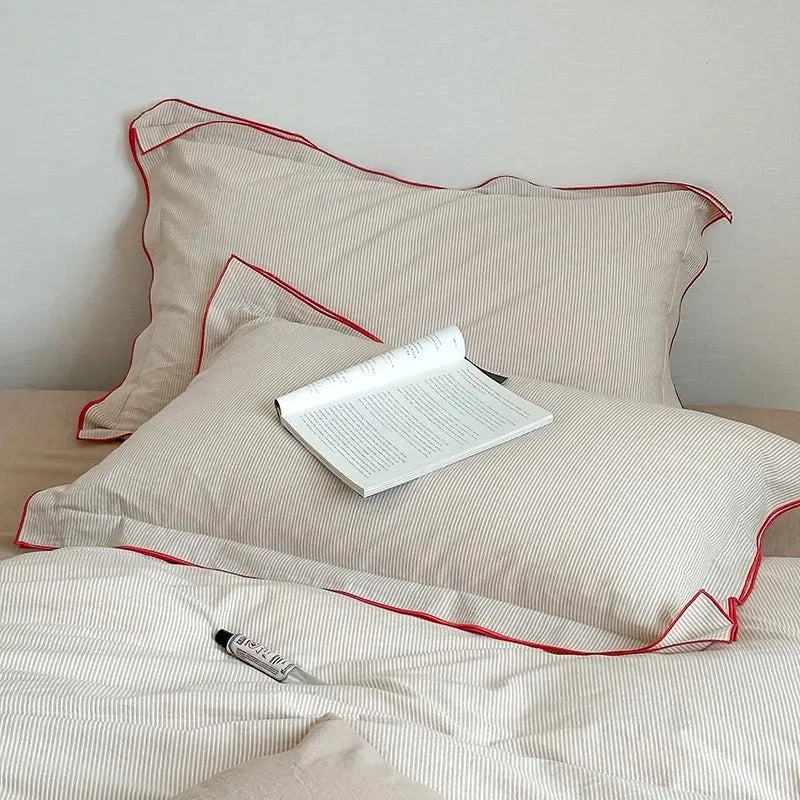 Beige pillows with red trim bedding set at The Happy Ladies