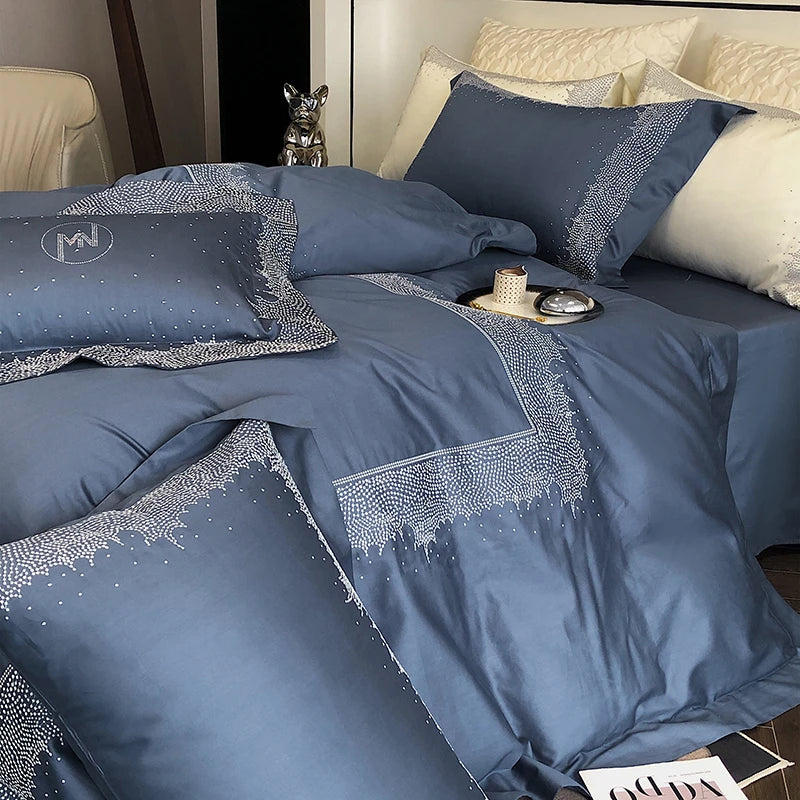Blue bedding set with decorative patterns on a bed in a bedroom.
