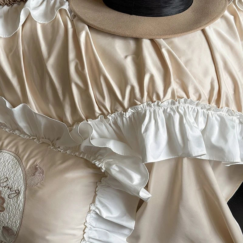 Close-up of a beige and white ruffled bedding set