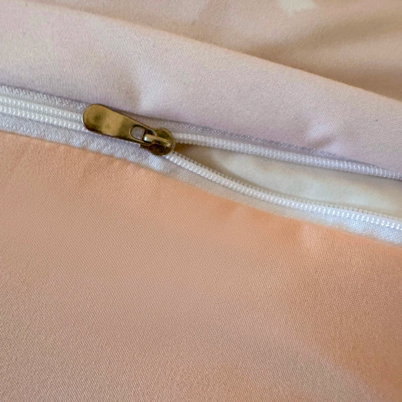 Close-up of a beige fabric with a white zipper and zipper pull.