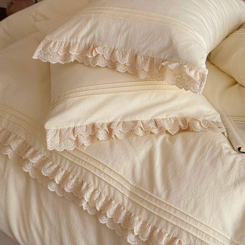 Close-up of beige bedding with lace trim on a bed.