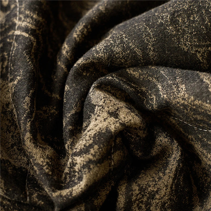 Close up of a textured black and golden quilted blanket