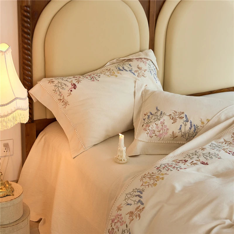 Decorative pillows and bedding with floral patterns on a bed in a bedroom setting.
