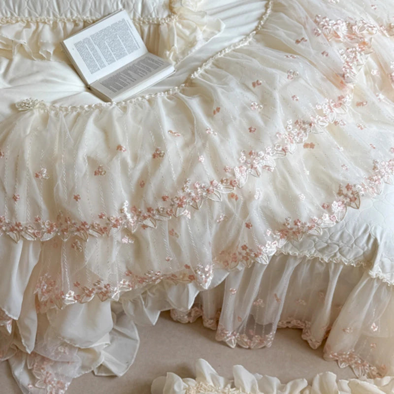 Delicate lace bedspread with floral embroidery on a textured surface