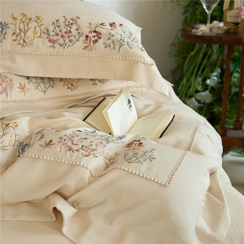 Embroidered beige bedding with floral patterns in a cozy room setting.