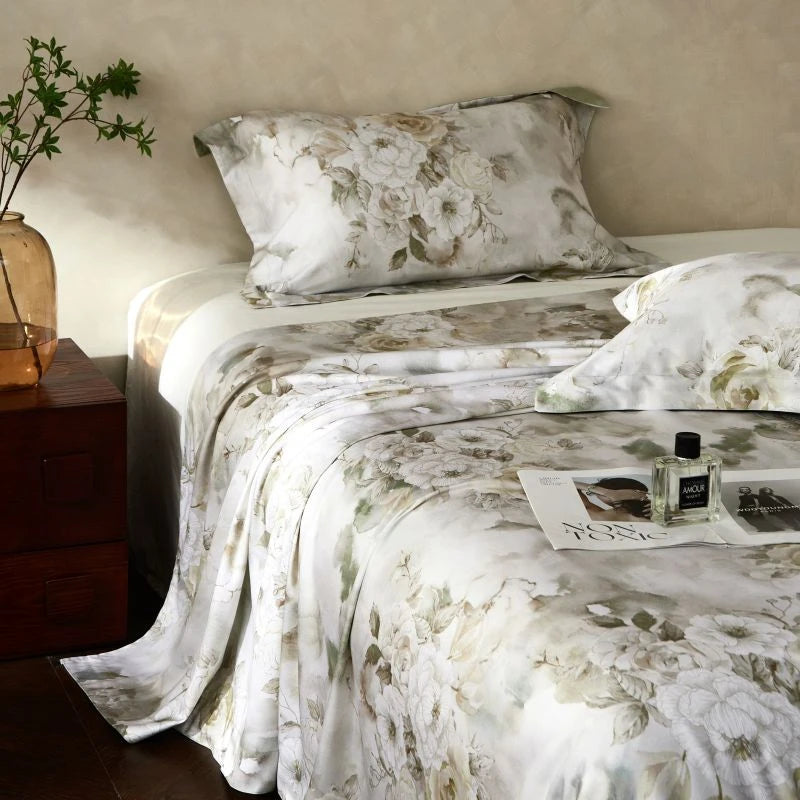 Floral bedding set on a bed with a side table and plant in the background