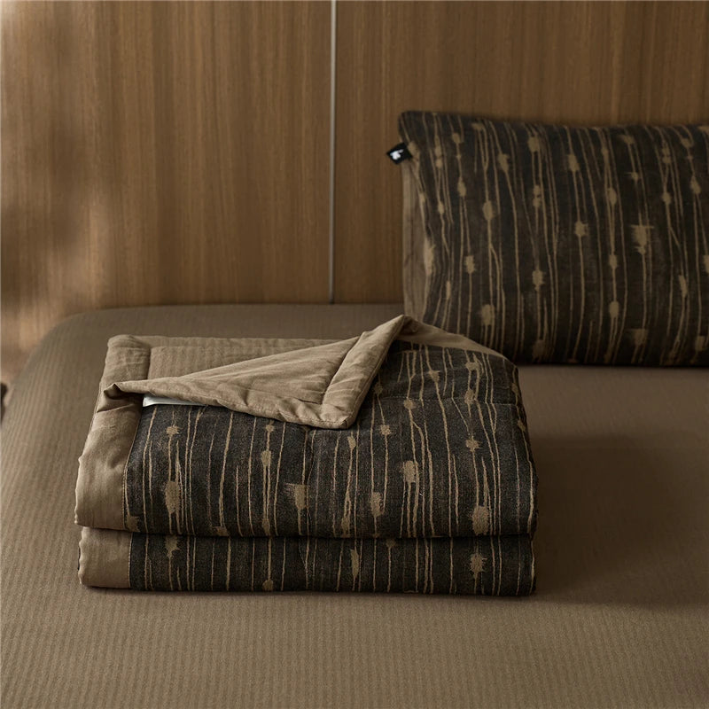 Folded brown and beige stripe quilted blanket