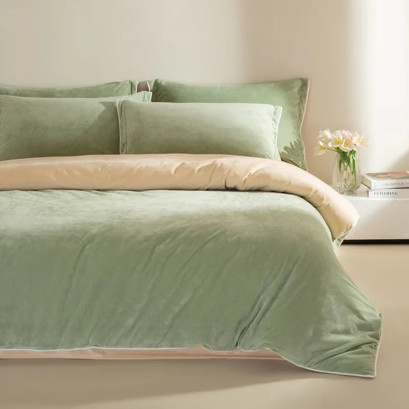 Green bedding set on a bed with a vase of flowers on a nightstand.