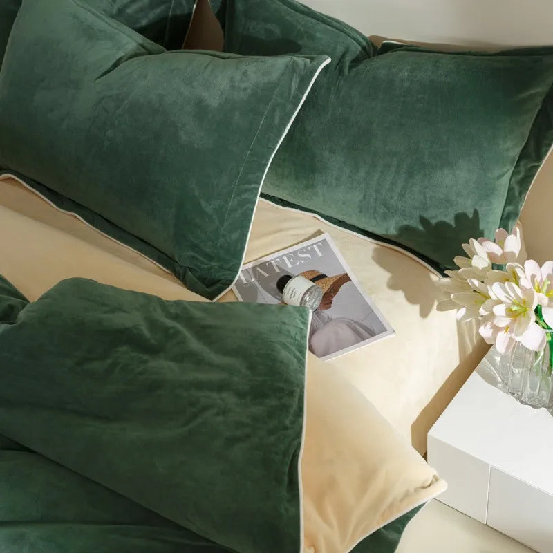 Green velvet pillows on a beige sofa with a magazine and flowers in the background.