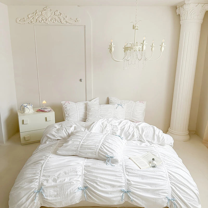 Neatly made white bed with white bedding in a bright bedroom.