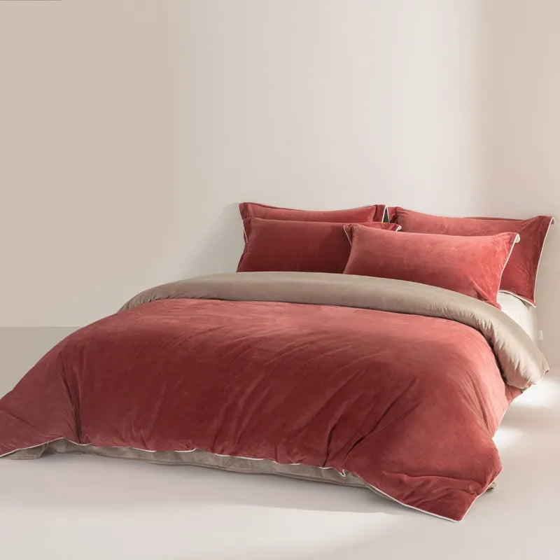 Rust velvet duvet set with matching pillows on a bed against a white wall.