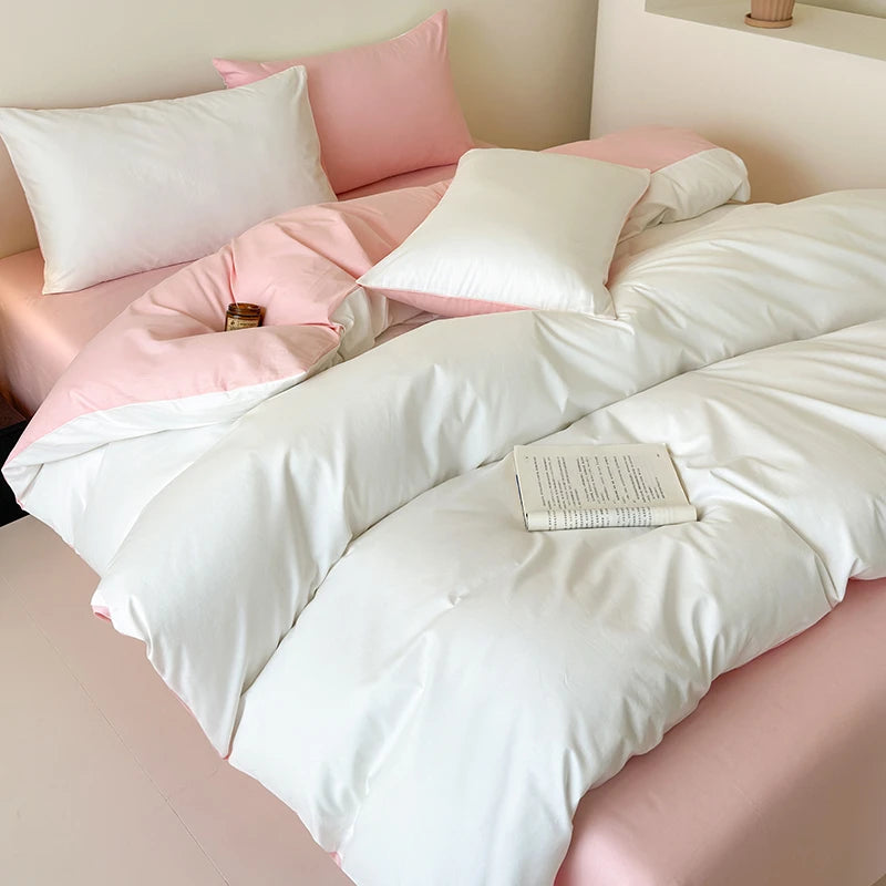White duvet cover set on a bed with pink pillows and a book.
