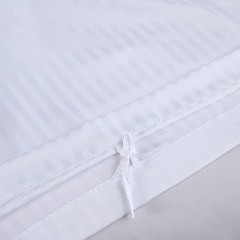 White fitted sheet with a small bow on a light gray background