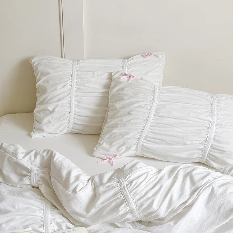 White textured pillows on a bed with a light background
